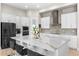 Bright kitchen features an island with white marble countertop, modern appliances and mosaic backsplash at 13182 Twin Bridges Dr, Riverview, FL 33579