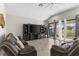 Bright living room with a large screen TV and sliding glass doors to the backyard at 13182 Twin Bridges Dr, Riverview, FL 33579