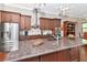 Island kitchen with granite countertops and stainless steel appliances at 13904 Shadow Tree Ln, Tampa, FL 33618