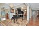 Bright living room with hardwood floors and a grand piano at 13904 Shadow Tree Ln, Tampa, FL 33618