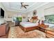 Spacious main bedroom with large windows, hardwood floors, and ceiling fan at 13904 Shadow Tree Ln, Tampa, FL 33618