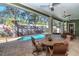 Covered patio with pool views, dining table, and seating at 13904 Shadow Tree Ln, Tampa, FL 33618