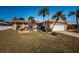 Tan house with white garage door and palm trees at 14993 Imperial Point N Dr, Largo, FL 33774