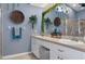 Charming bathroom featuring double sinks, decorative mirror and hanging decorative plants at 18026 Macy Rd, Weeki Wachee, FL 34614