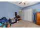 Spare bedroom featuring blue walls, carpet, fan and furniture at 18026 Macy Rd, Weeki Wachee, FL 34614