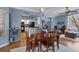 Open dining area featuring wood flooring, a wooden dining table, neutral paint tones, and kitchen views at 18026 Macy Rd, Weeki Wachee, FL 34614