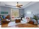 Bright living room featuring a large window, neutral paint tones, ceiling fan, and comfortable furniture at 18026 Macy Rd, Weeki Wachee, FL 34614