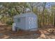 Backyard utility shed with double doors and a small window, adding functionality to the outdoor space at 18026 Macy Rd, Weeki Wachee, FL 34614