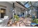 Relaxing outdoor screened patio with seating, a dining table, and views of a lush garden at 18026 Macy Rd, Weeki Wachee, FL 34614