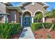 Front entrance with teal double doors and landscaping at 2659 Keystone Springs Rd, Tarpon Springs, FL 34688