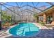 Inviting kidney-shaped pool with screened enclosure at 2659 Keystone Springs Rd, Tarpon Springs, FL 34688