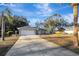 Gray house with white garage door, landscaping, and a palm tree in the front yard at 2733 Glenview Dr, Land O Lakes, FL 34639