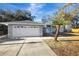 Gray house with white two-car garage, walkway, and landscaping at 2733 Glenview Dr, Land O Lakes, FL 34639