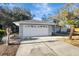 Two-car garage with white door, gray house exterior and landscaping at 2733 Glenview Dr, Land O Lakes, FL 34639