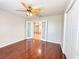 Bedroom features hardwood floors, fan and light fixture, with french doors leading to another room at 286 Royal Palm Way, Spring Hill, FL 34608