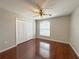 Bedroom features hardwood floors, fan and light fixture, and a closet for storage at 286 Royal Palm Way, Spring Hill, FL 34608