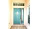 Teal front door with glass panels and sidelights at 286 Royal Palm Way, Spring Hill, FL 34608