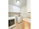 Laundry room with washer, dryer, and a wash basin with white cabinets for storage and a towel rack at 286 Royal Palm Way, Spring Hill, FL 34608