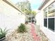 Landscaped side yard with a stone pathway and lighting at 286 Royal Palm Way, Spring Hill, FL 34608