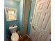 Bathroom featuring a toilet, window, tall linen closet, and modern blue paint at 3301 Alt 19 # 126, Palm Harbor, FL 34683