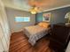 Cozy bedroom featuring a ceiling fan, laminate wood floors, and a comfortable bed at 3301 Alt 19 # 126, Palm Harbor, FL 34683