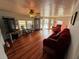 Bright living room with wood floors, multiple seating areas, and a large window at 3301 Alt 19 # 126, Palm Harbor, FL 34683