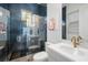 Modern bathroom featuring blue tile shower, white vanity, gold fixtures, and patterned floor at 33843 Galley Way, Wesley Chapel, FL 33543