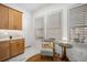 Bright laundry room with wooden cabinets and window seat at 33843 Galley Way, Wesley Chapel, FL 33543