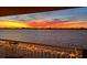 Balcony view of a vibrant sunset over the water, framed by a lighted railing at 370 8Th N Ave # 7, Tierra Verde, FL 33715