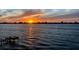 A scenic view of a sunset over the water, with a dock silhouetted on the horizon at 370 8Th N Ave # 7, Tierra Verde, FL 33715