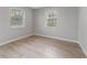 Well-lit bedroom with two windows and wood-look floors at 4724 W Lawn Ave, Tampa, FL 33611