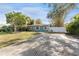 Gray house with blue door, landscaped yard, and a long driveway at 4724 W Lawn Ave, Tampa, FL 33611