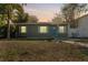 Front view of a charming gray house at dusk with lights on at 4724 W Lawn Ave, Tampa, FL 33611