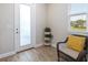 A bright foyer with a wicker chair and a three-tiered plant stand at 4761 San Martino Dr, Wesley Chapel, FL 33543