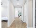 A light hallway with wood flooring connecting different rooms at 4761 San Martino Dr, Wesley Chapel, FL 33543