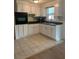 White kitchen with ample cabinet space and tile flooring at 4940 Rosedale Ln, Holiday, FL 34690