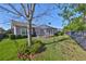 Landscaped backyard with screened patio and fenced area at 6321 Voyagers Pl, Apollo Beach, FL 33572