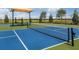 Newly-built pickleball court with blue and green surface and a shaded seating area at 6321 Voyagers Pl, Apollo Beach, FL 33572