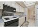 White appliances and cabinets are featured in this galley kitchen at 644 Island Way # 206, Clearwater, FL 33767