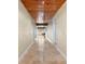 Long hallway with travertine tile floors and wood ceilings at 7007 Lambright Ct, Tampa, FL 33634