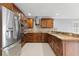 L-shaped kitchen with wood cabinets and granite countertops at 7007 Lambright Ct, Tampa, FL 33634