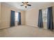 Bedroom featuring neutral colored walls, carpet, with two windows and blue drapes at 7401 Watersilk Dr, Pinellas Park, FL 33782