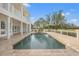 A beautiful backyard pool is surrounded by brick pavers and a white fence and columned patio at 7401 Watersilk Dr, Pinellas Park, FL 33782