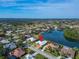 Aerial view of the home and the community with a lake at 7566 Links Ct, Sarasota, FL 34243