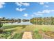 Backyard view of the lake with a brick path leading to the water at 7566 Links Ct, Sarasota, FL 34243