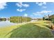 Backyard view of the lake with lush green grass leading to the water at 7566 Links Ct, Sarasota, FL 34243