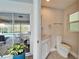 Powder room featuring tile floors, a sink with vanity, and slider to screened lanai with pool and lake views at 7566 Links Ct, Sarasota, FL 34243