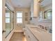 Bright bathroom featuring a shower-tub combo, shaker cabinets, and a framed mirror at 7566 Links Ct, Sarasota, FL 34243