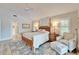 Cozy bedroom with decorative rug, chair, ottoman, plantation shutters, and wood-framed bed at 7566 Links Ct, Sarasota, FL 34243