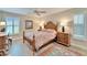 Bedroom with patterned bedding, plantation shutters, wood flooring and matching wood bedside tables at 7566 Links Ct, Sarasota, FL 34243